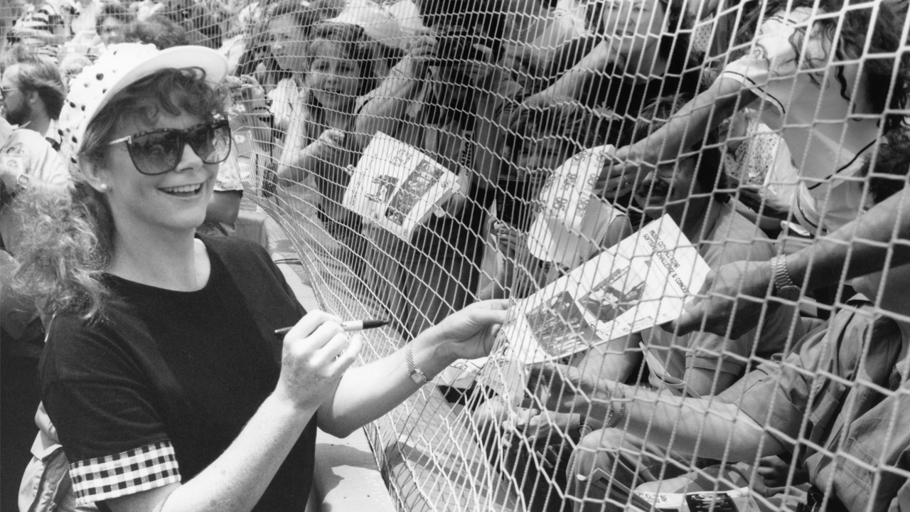 Reba signs autograph of fans through fence 